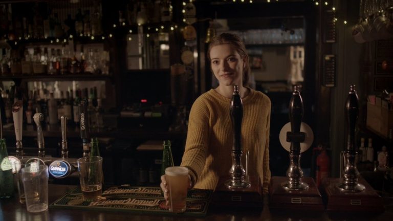 Woman is serving beer in a pub
