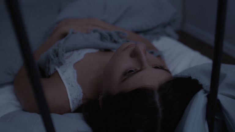 Woman looks up in bed