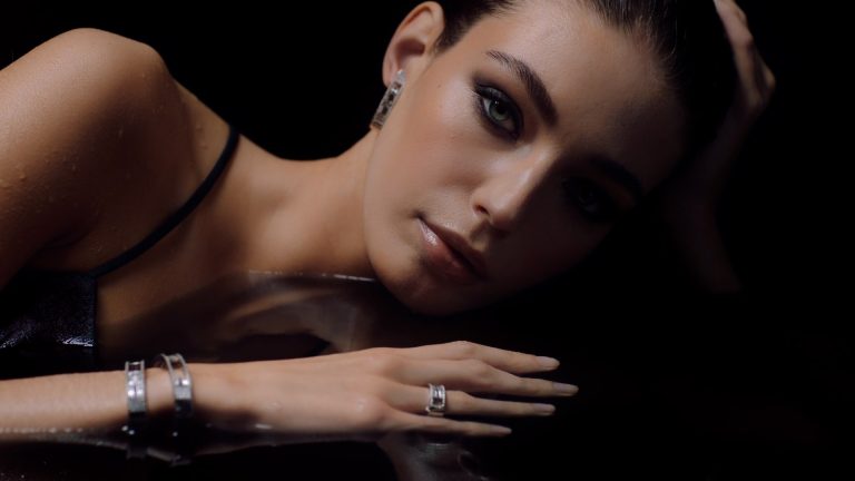 Model looks in the camera while laying in water. High contrast.