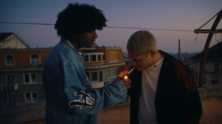 2 guys smoking cigarette on the rooftop during sunset