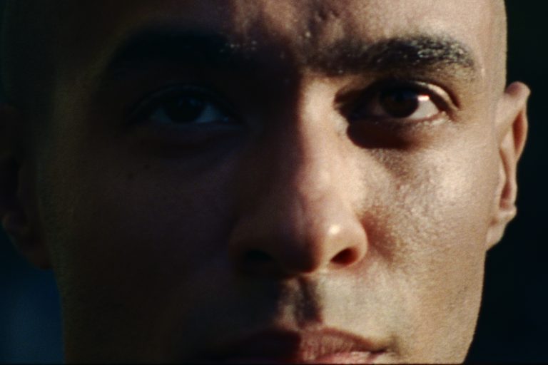 Extreme close-up of a sweating basketball player’s face in low light, from E x H – Chasing the Shot for Huel